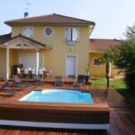 Terrasse bois foncé sur mesure autour d’une piscine réalisée par la Menuiserie Jouve